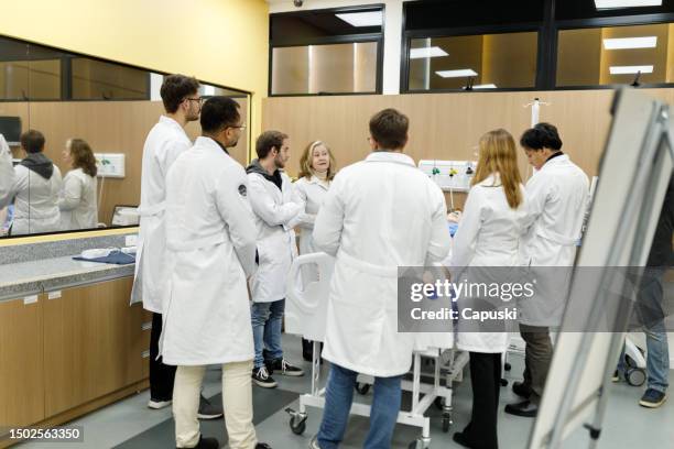 studenti di medicina che imparano a conoscere le gravidanze a rischio durante le lezioni pratiche - campo-di-allenamento foto e immagini stock
