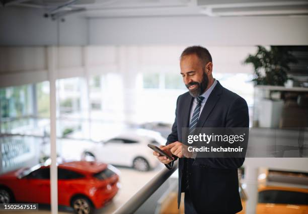 mid aged man working in the car showroom - sports car showroom stock pictures, royalty-free photos & images