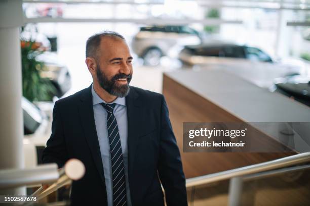 mid aged businessman in a car dealership - honda dealer stock pictures, royalty-free photos & images