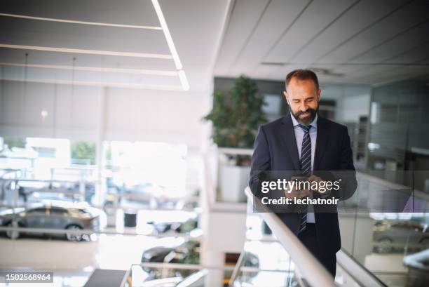 mid aged man working in the car showroom - honda dealer stock pictures, royalty-free photos & images