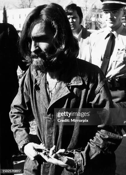 Charles Manson. Hippie cult leader being lead away by police after being accused of six murders, of which Sharon Tate is one of the victims.