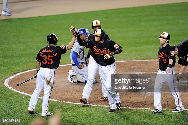 Manny Machado of the Baltimore Orioles celebrates with Omar Quintanilla, Wilson Betemit and Nate McLouth after hitting a home run in the sixth inning...