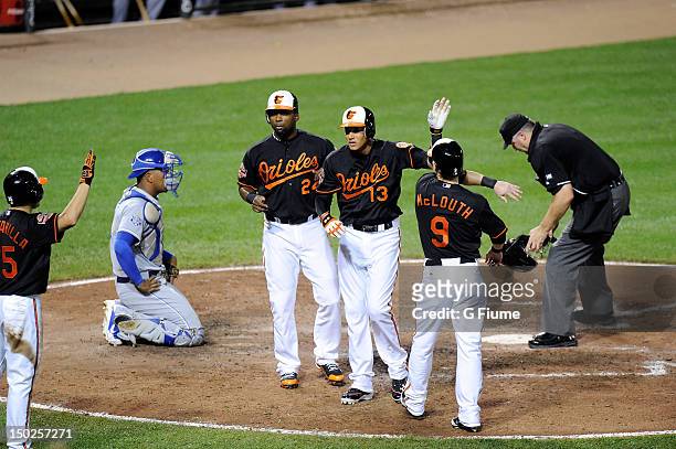 Manny Machado of the Baltimore Orioles celebrates with Wilson Betemit and Nate McLouth after hitting a home run in the sixth inning against the...