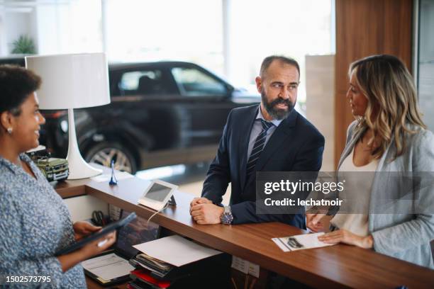 mid age couple in the car showroom - luxury 4x4 stock pictures, royalty-free photos & images