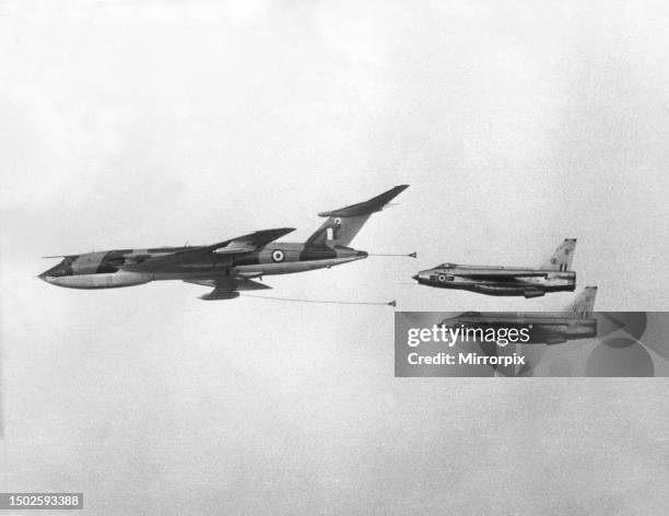 Two RAF English Electric Lightning jet fighter aircraft prepare to refuel from a Handley Page Victor tanker aircraft during a flypast at a RAF...