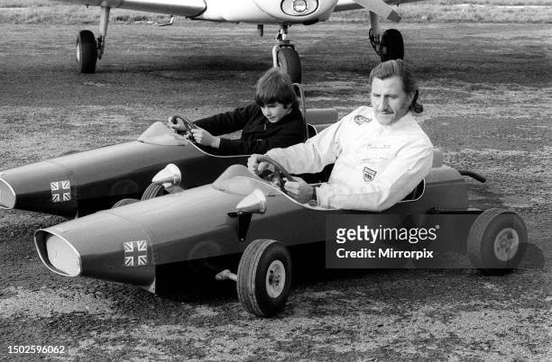 Racing driver Graham Hill races son Damon in their toy cars, at Elstree aerodrome