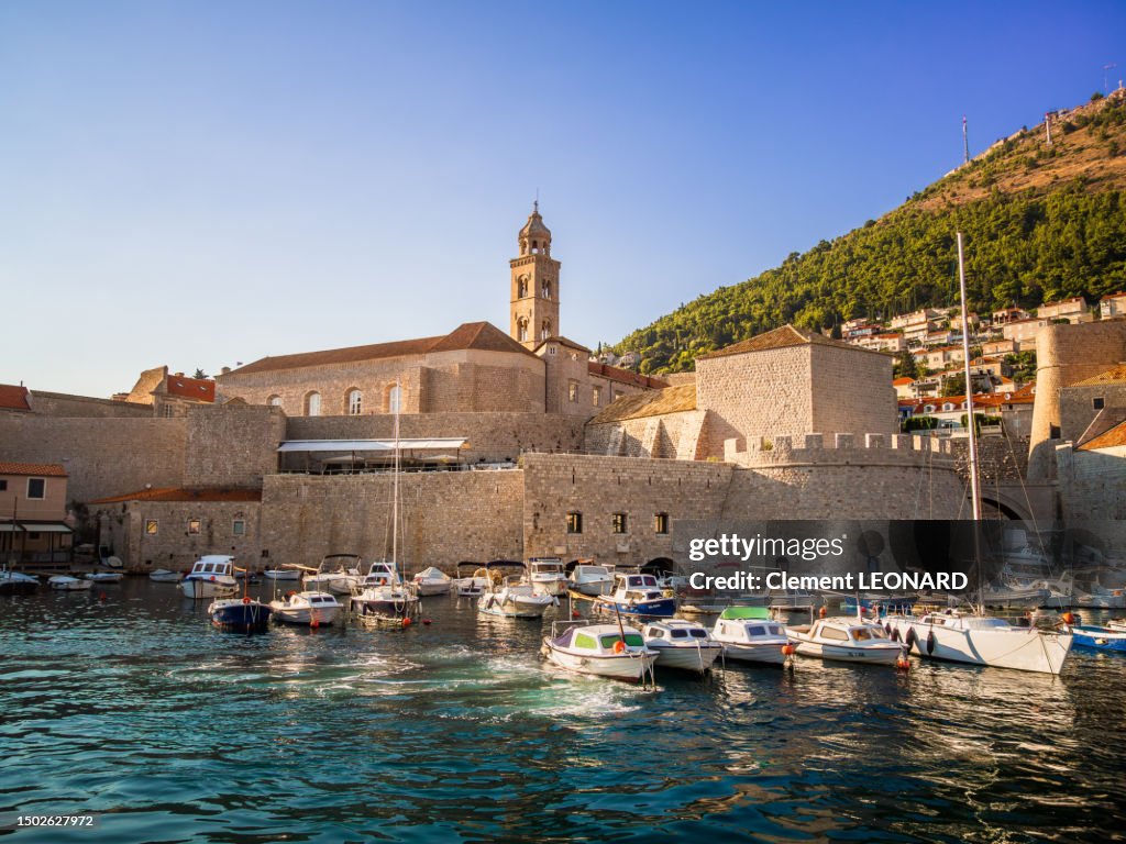 Wide angle view of the old port in Dubrovnik old town with the fortified walls in the background, Dalmatia, Croatia.