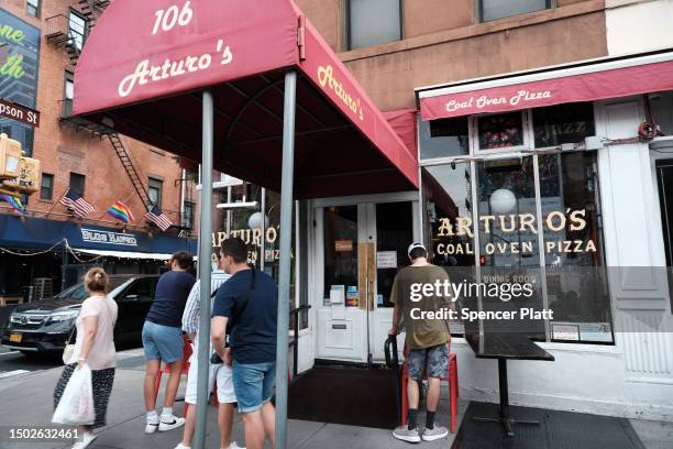 People wait outside of Arturo's, a famed New York City restaurant that makes coal oven pizzas, on June 26, 2023 in New York City. The New York City...