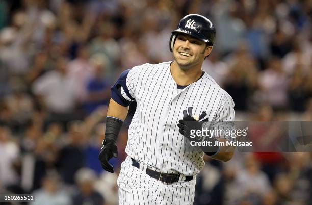 Nick Swisher of the New York Yankees smiles at his dugout as he runs the bases after his third inning grand slam against the Texas Rangers at Yankee...