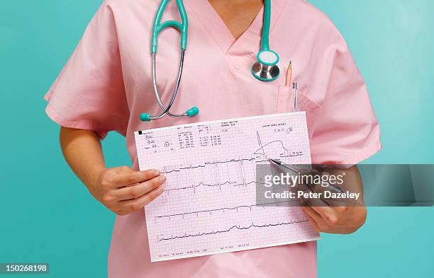a doctor holding a print-out of an ecg graph - pulse trace stock pictures, royalty-free photos & images