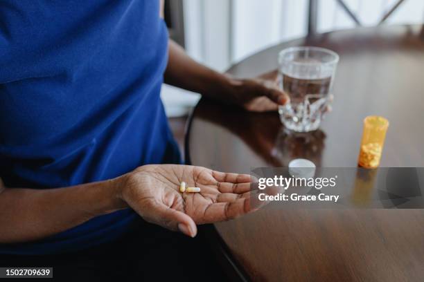woman takes her medicine - ibuprofen stock pictures, royalty-free photos & images