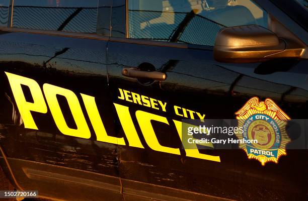 The rising sun illuminates the side of a Jersey City Police Department car on June 25 in Jersey City, New Jersey.