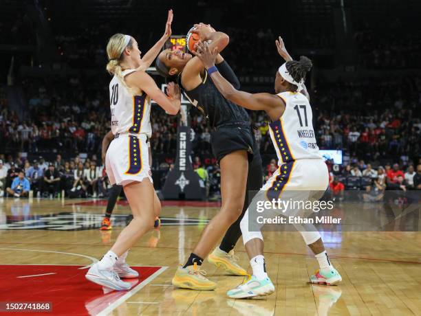 Ja Wilson of the Las Vegas Aces is fouled by Erica Wheeler of the Indiana Fever as Lexie Hull of the Fever defends in the second quarter of their...