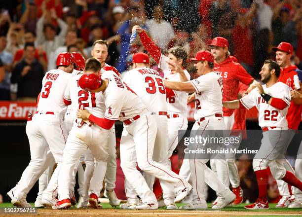 Mike Trout of the Los Angeles Angels celebrates after scoring the game winning run after a wild pitch by Aaron Bummer of the Chicago White Sox at...