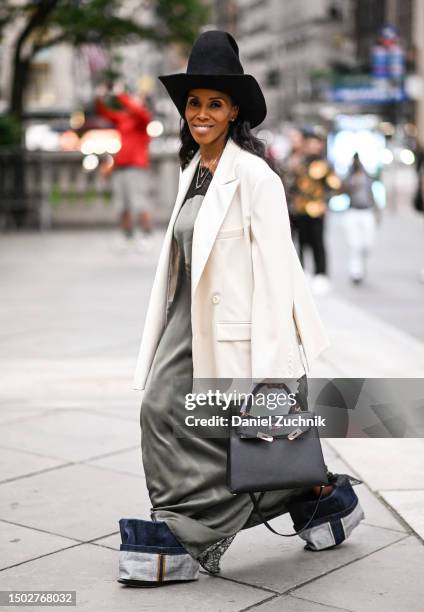 June Ambrose is seen wearing a black hat, white jacket and green dress, denim shoes with black Hermes bag outside the Marc Jacobs show on June 26,...