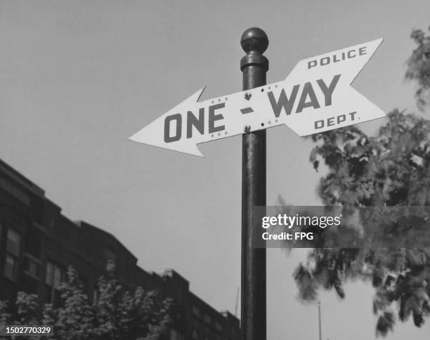 Police Dept sign in the shape of an arrow, on which is printed 'One-Way', United States, circa 1955.