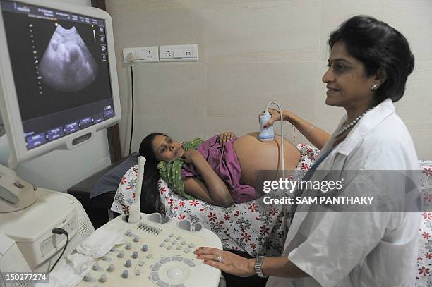 Dr. Nayna Patel , a pioneer of reproductive surrogacy in India, conducts an ultrasound on 30 year old surrogate mother - Rinku Macwan, bearing twin...