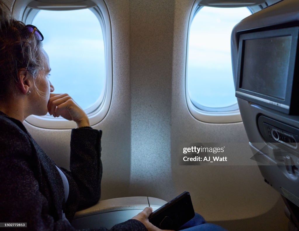 Mujer viajera en el avión mirando por la ventana