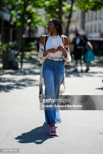 Guest wears white transparent and blue glasses, a white halter-neck tank-top, a white with green and red flower print pattern silk long kimono, a...