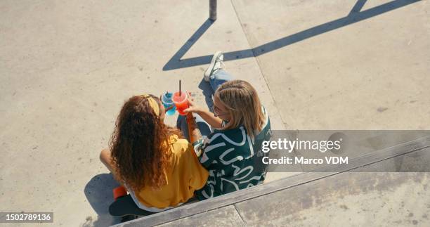 cheers, bonding and female friends in the city sitting and talking about gossip with drinks. happy, conversation and top view of women speaking while drinking beverage on the pavement in urban town. - slush stock pictures, royalty-free photos & images