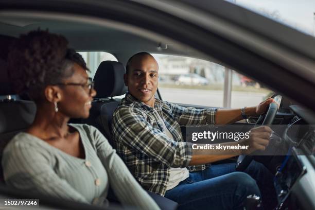 happy black couple talking during a trip in a car. - test drive stock pictures, royalty-free photos & images