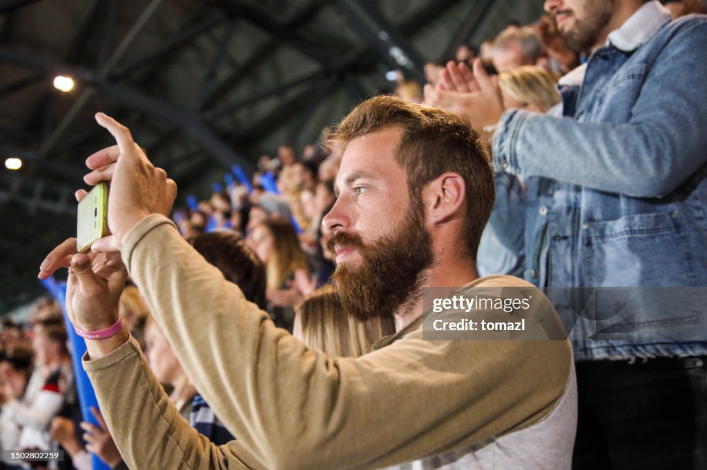 Man photographing at a footbal match