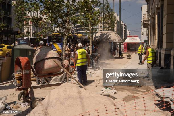 Construction workers pave a sidewalk in Athens, Greece, on Wednesday, July 5, 2023. Prime Minister Kyriakos Mitsotakis pledged to bring incomes for...