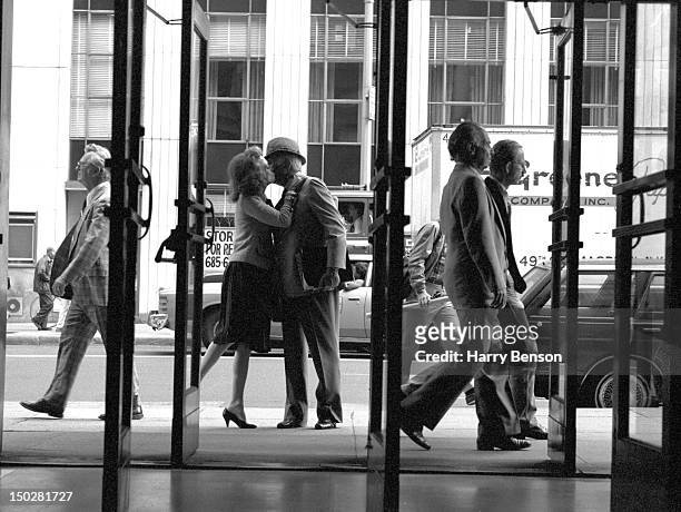Publisher and author Helen Gurley Brown photographed outside the Cosmopolitan offices kissing her husband David Brown goodbye, one morning, in 1982...