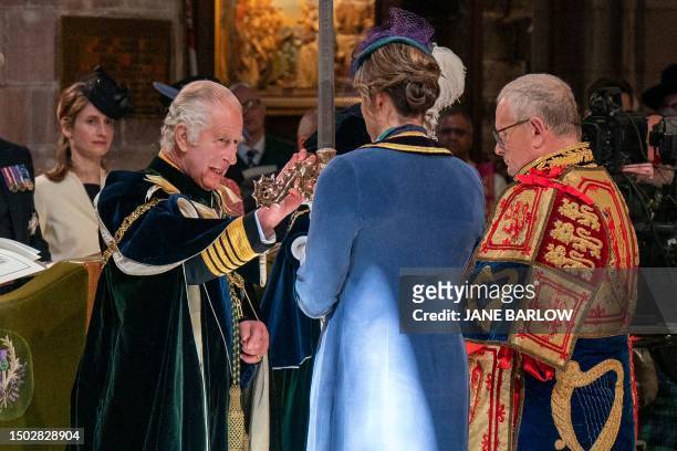 Britain's King Charles III is presented with the Elizabeth Sword, part of the Honours of Scotland, by Olympic rower Katherine Grainger during a...