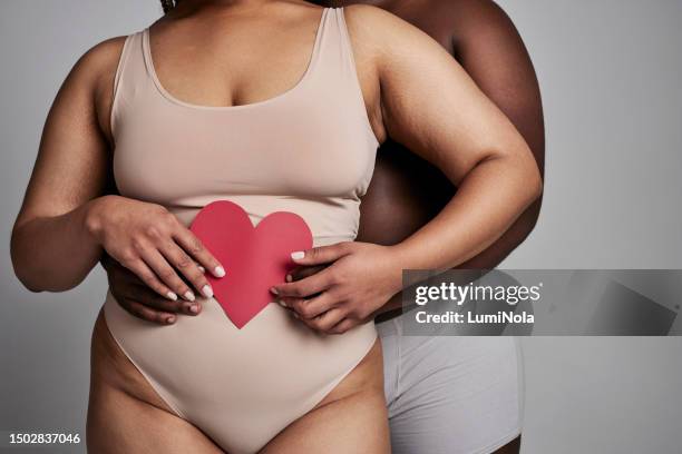 paper heart, love and plus size couple with hands in studio with romance and valentines day icon. gray background, people and sign with body positive, woman and man in underwear with relationship - poster size stock pictures, royalty-free photos & images