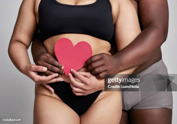 paper, heart emoji and plus size couple with hands in a studio with romance and valentines day icon. gray background, people and love sign with poster, woman and man in underwear with relationship - poster size stock pictures, royalty-free photos & images