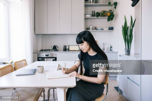 female writer writing in her notebook. - copy writing stock pictures, royalty-free photos & images