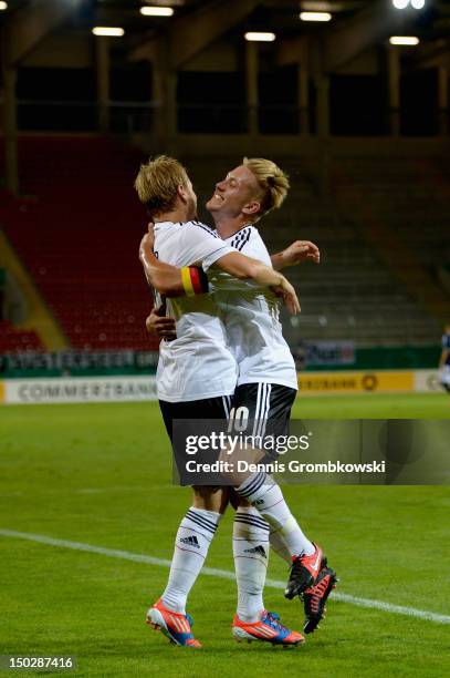 Maximilian Beister of Germany celebrates with teammate Lewis Holtby after scoring his team's third goal during the Under 21 international friendly...