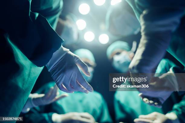 four surgeons discuss each other surgical precision and healthcare expertise before the operation case - medical procedure stock pictures, royalty-free photos & images