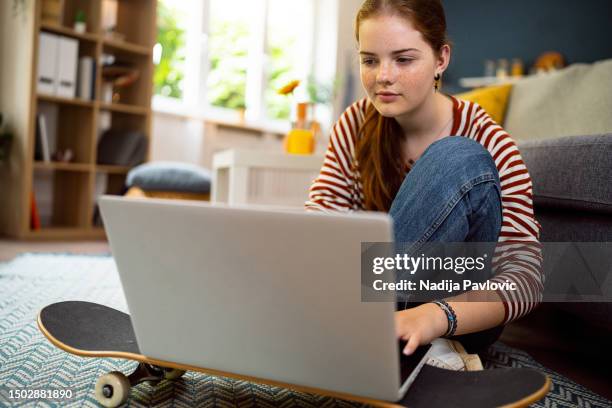 redhead teenage girl using laptop at home - female high school student stock pictures, royalty-free photos & images