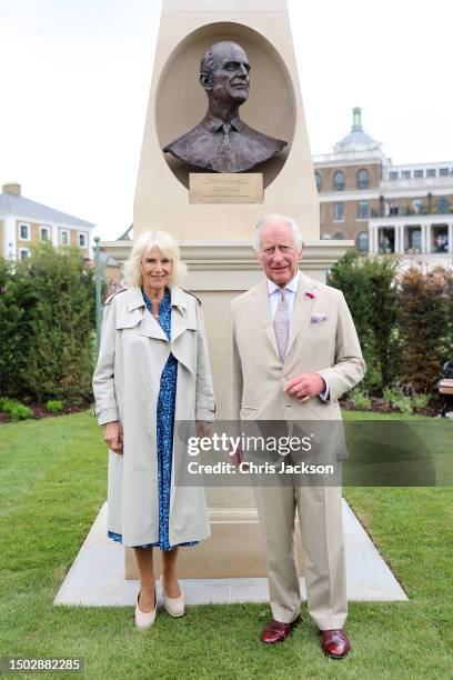 King Charles III and Queen Camilla pose at the bronze bust of Prince Philip, Duke of Edinburgh as they visit Poundbury at Poundbury on June 27, 2023...