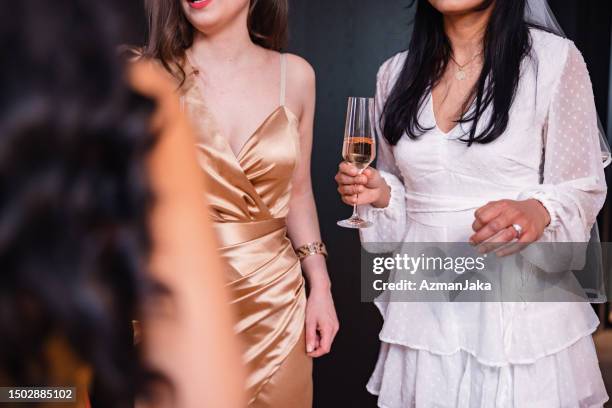 close up of a bride-to-be holding a glass of champagne during her bachelorette party - banquet speech stock pictures, royalty-free photos & images