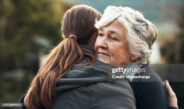 thinking, person or old woman hug for comfort, grief and care after bad news or problems in a park. cancer, depressed elderly lady or sad people hugging for empathy, love and hope together in nature - grief loss stock pictures, royalty-free photos & images