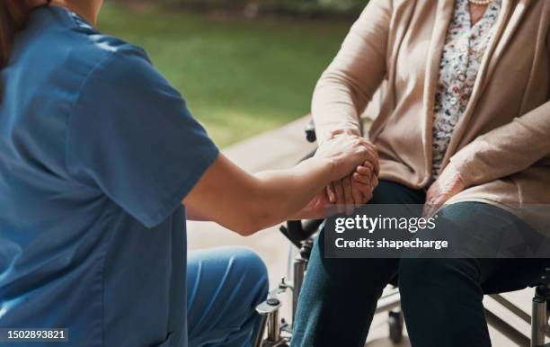 nurse, holding hands and senior woman in wheelchair with help or support for health or wellness. elderly patient person with disability and caregiver together for healthcare, kindness or medical care - kind 個照片及圖片檔