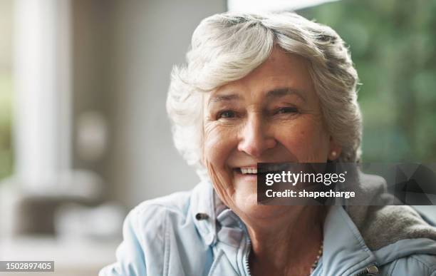 happy, relax and portrait of a senior woman in a house for comfort, peace and retirement. smile, face and a beautiful elderly person in a living room of a lounge with confidence in a nursing home - charming stockfoto's en -beelden