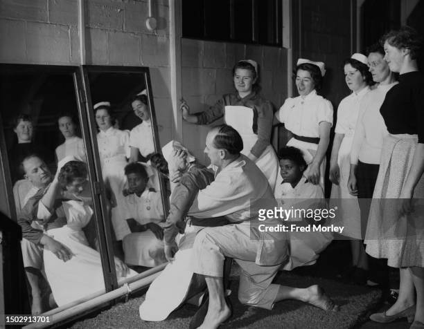 Judo instructor Donald IL Butler holds Irish nurse Maria Lenehan in a back stranglehold as nursing staff receive instruction in the art of judo, at...