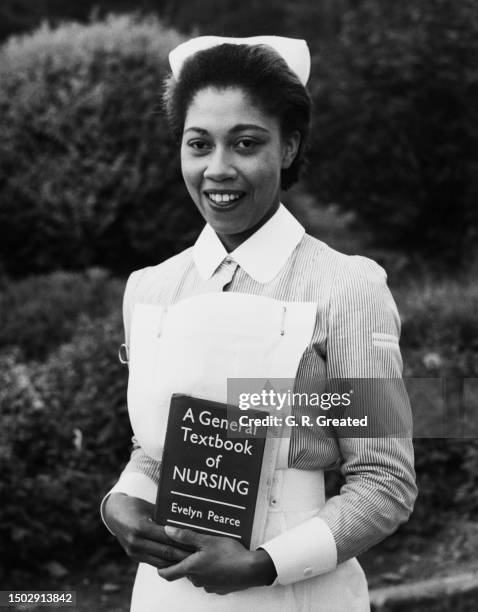 Bermudian student nurse Francis Mills in uniform and holding the copy of 'A General Textbook of Nursing' which she received as her 'Best Practical...