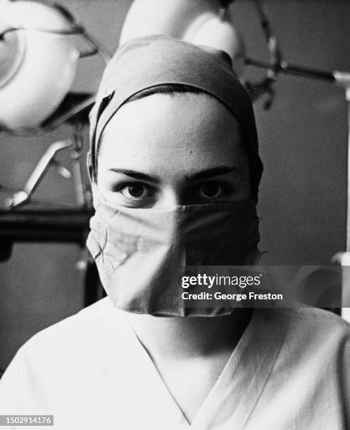 Theatre nurse, her face partially obscured by a facemask, in the operating theatre at St Bartholomew's Hospital in London, England, February 1968.