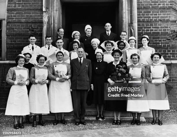 Matron CA Howard between Captain AR Martin and his wife pose for a group portrait with nurses after the Student Nurses' Prizegiving Ceremony at the...
