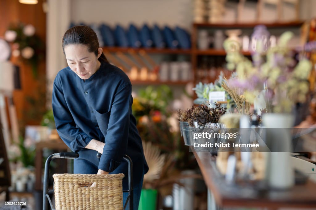 Eco-friendly Products Can Help Retailers to Increase Customer Loyalty and Retention by Evidencing Environmental Success. A female customer chose a home decor product made of recycled material from the shelf in a furniture store.