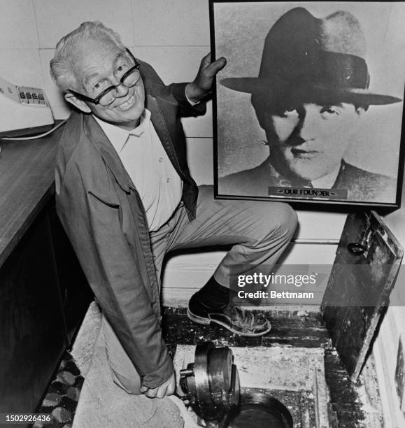 Don Garvin, an engineer with the Flamingo Hotel in Las Vegas, poses with a picture of gangster Bugsy Siegel next to a floor safe discovered at the...