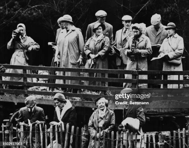 Princess Margaret and Queen Elizabeth II take photographs at the Badminton Horse Trials in Gloucestershire, England, April 18th 1959. To the left of...