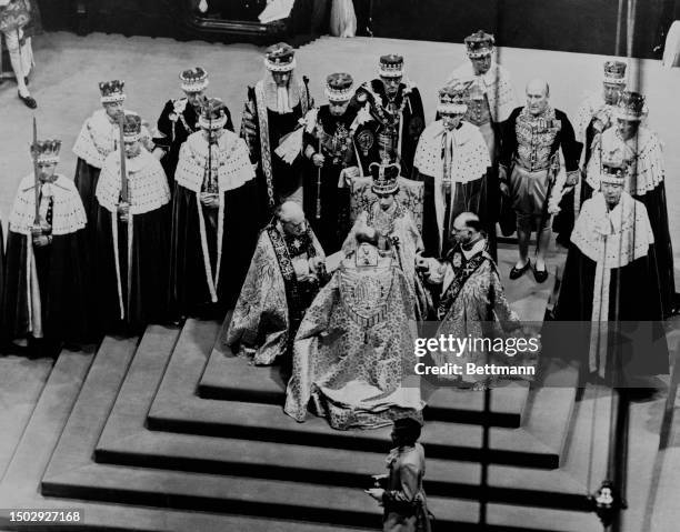Queen Elizabeth II is attended by dignitaries whilst bishops pay homage to her during her coronation ceremony at Westminster Abbey in London, June...