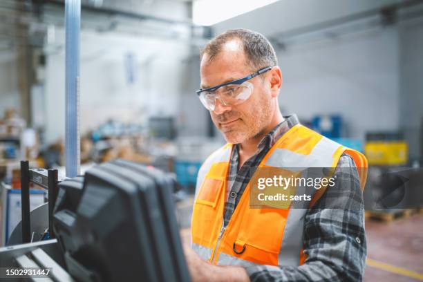 operaio che lavora in fabbrica - occhiali protettivi foto e immagini stock