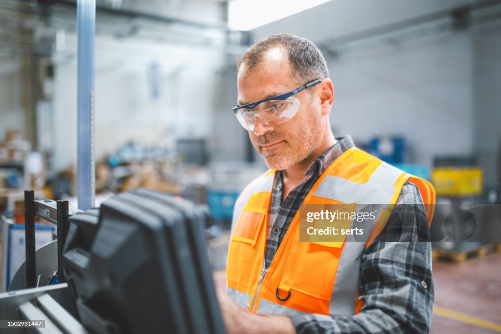 Homem manual do trabalhador que trabalha na fábrica de fabricação